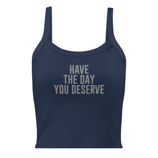 "Have the day you deserve" printed on a solid navy blend women's micro-rib tanktop laying on a flat surface