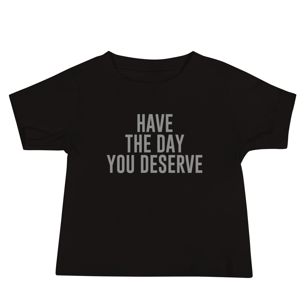 "Have the day you deserve" printed on a black baby jersey short sleeve tee laying on a flat surface