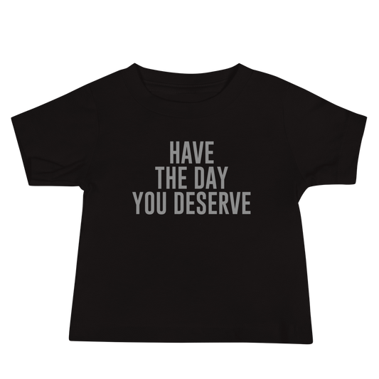 "Have the day you deserve" printed on a black baby jersey short sleeve tee laying on a flat surface