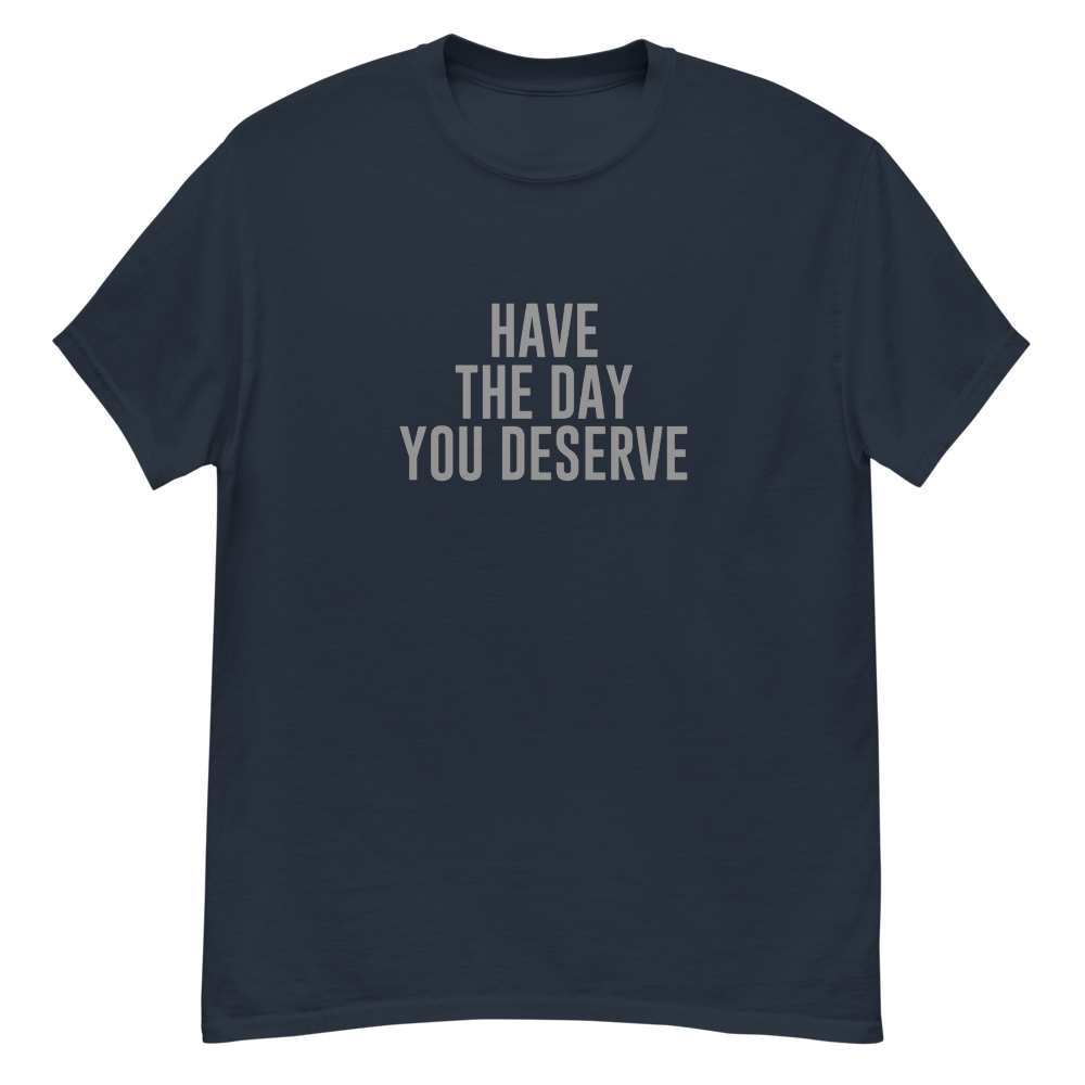 "Have the day you deserve" printed on a navy unisex classic tee laying on a flat surface