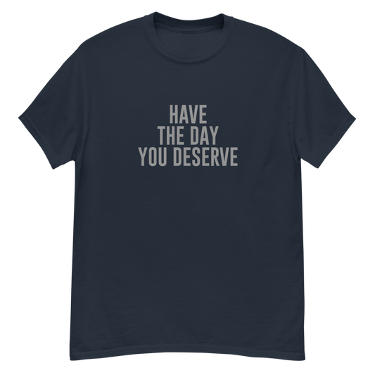 "Have the day you deserve" printed on a navy unisex classic tee laying on a flat surface