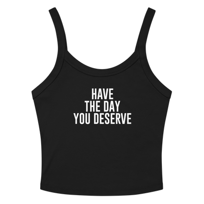 "Have the day you deserve" printed on a solid black blend women's micro-rib tanktop laying on a flat surface amongst sunglasses and shorts