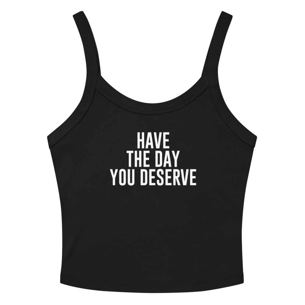 "Have the day you deserve" printed on a solid black blend women's micro-rib tanktop laying on a flat surface amongst sunglasses and shorts