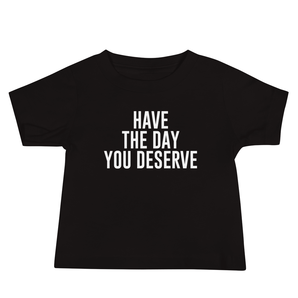 "Have the day you deserve" printed on a black baby jersey short sleeve tee laying on a flat surface