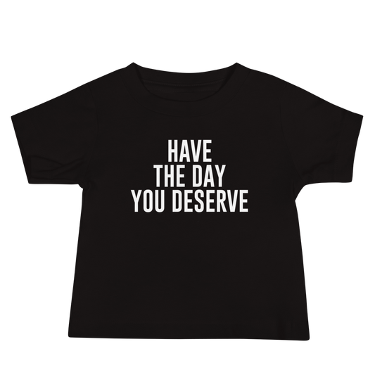 "Have the day you deserve" printed on a black baby jersey short sleeve tee laying on a flat surface