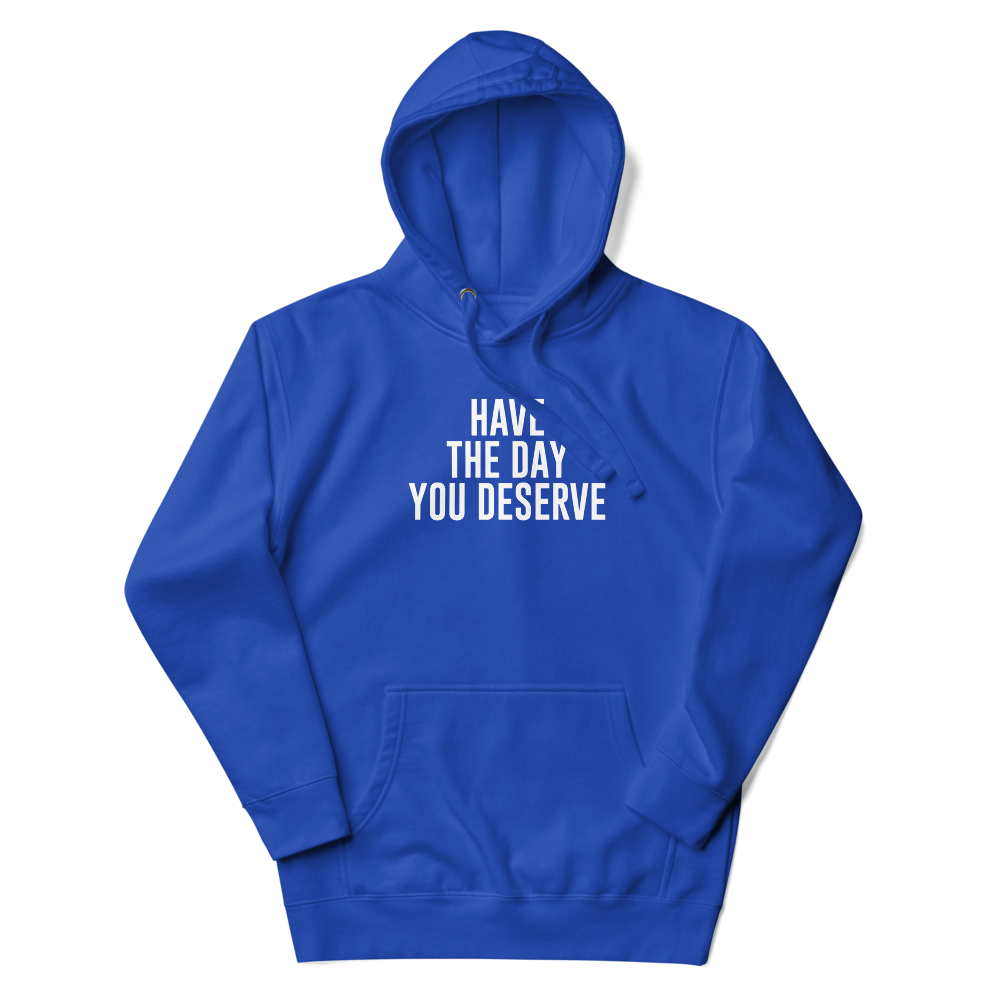 "Have the day you deserve" printed on a team royal unisex hoodie laying on a flat surface with the hood up