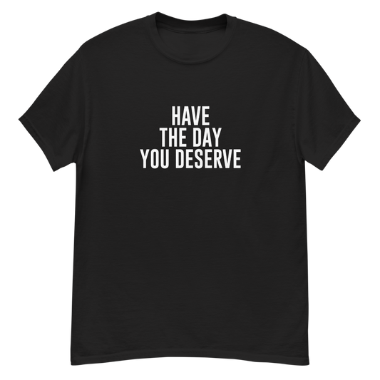 "Have the day you deserve" printed on a black unisex classic tee laying on a flat surface
