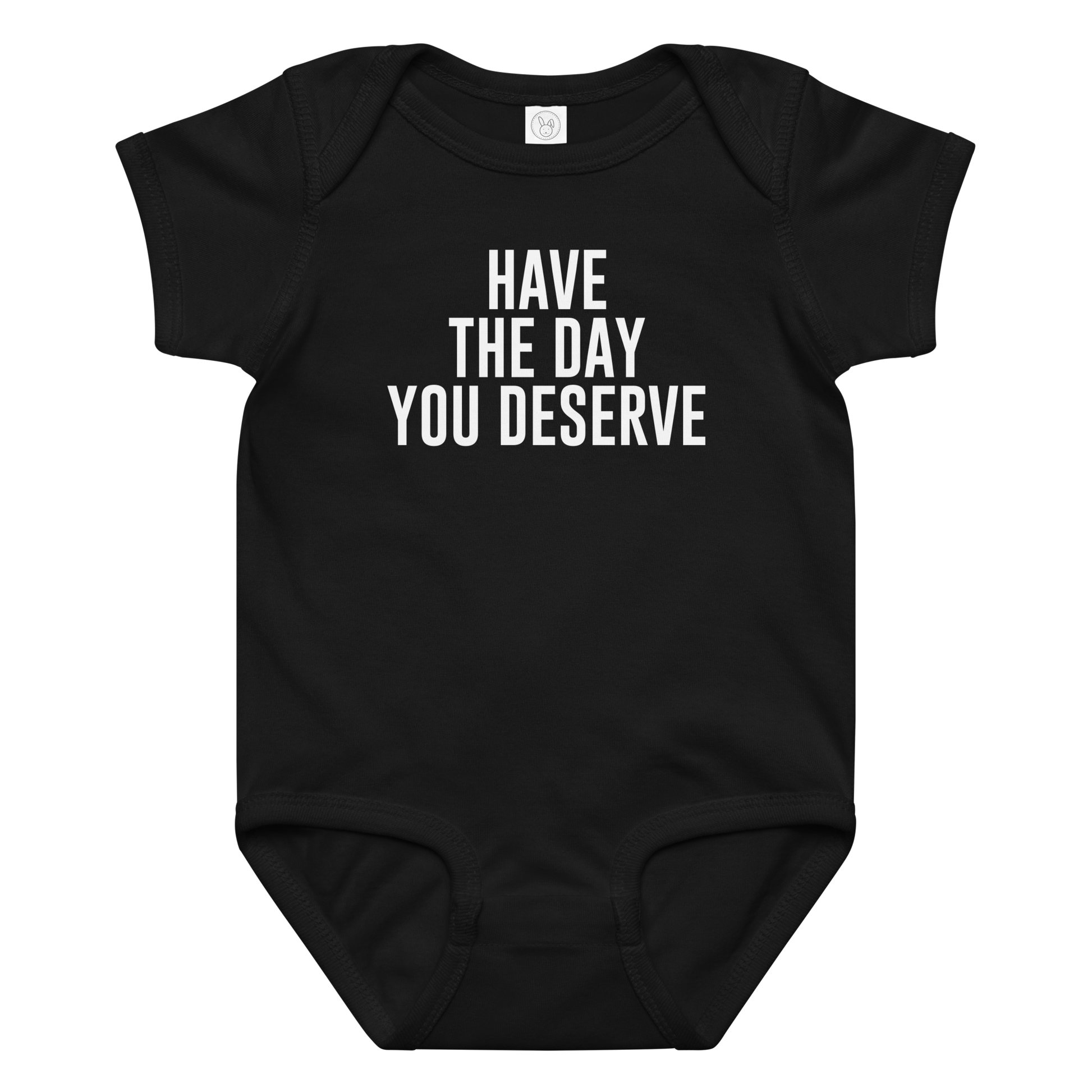 "Have the day you deserve" printed on a black baby jersey bodysuit laying on a flat surface amongst other clothes