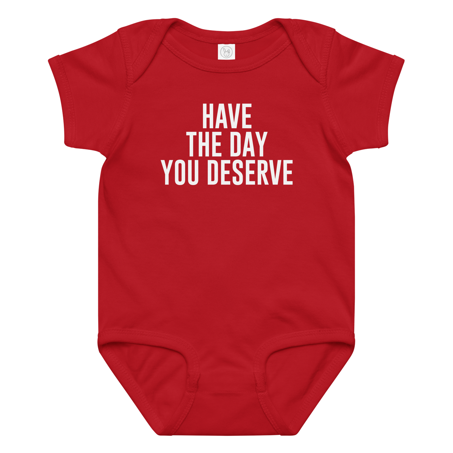 "Have the day you deserve" printed on a red baby jersey bodysuit laying on a flat surface amongst other clothes