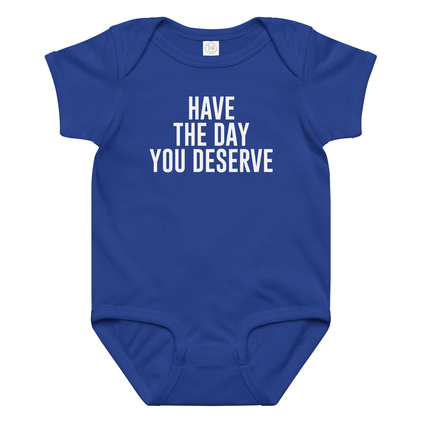 "Have the day you deserve" printed on a royal baby jersey bodysuit laying on a flat surface amongst other clothes
