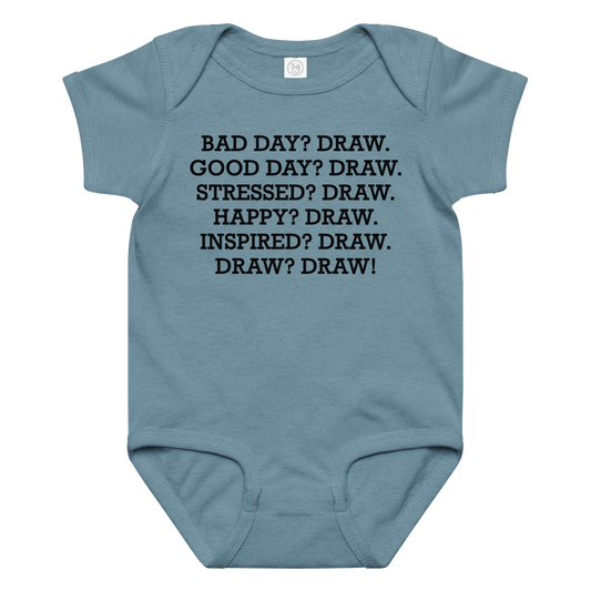 "Bad Day? Draw. Good Day? Draw. Stressed? Draw. Happy? Draw. Inspired? Draw. Draw? Draw!" printed on a vintage indigo baby jersey bodysuit laying on a flat surface amongst other clothes