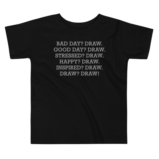 "Bad Day? Draw. Good Day? Draw. Stressed? Draw. Happy? Draw. Inspired? Draw. Draw? Draw!" printed on a black toddler short sleeve tee laying on a flat surface