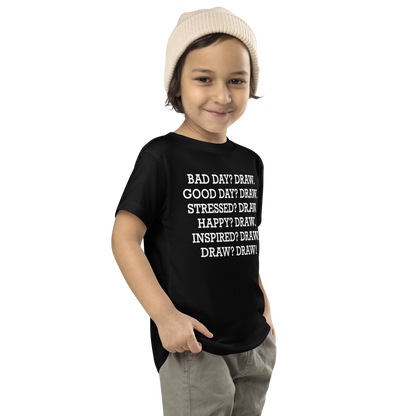 "Bad Day? Draw. Good Day? Draw. Stressed? Draw. Happy? Draw. Inspired? Draw. Draw? Draw!" printed on a black toddler short sleeve tee worn by a male who is also wearing a knit cap