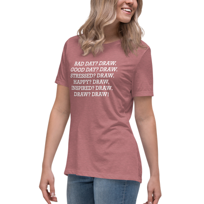 "Bad Day? Draw. Good Day? Draw. Stressed? Draw. Happy? Draw. Inspired? Draw. Draw? Draw!" printed on a heather mauve women's relaxed t-shirt worn by a female