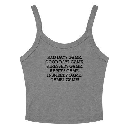 "Bad Day? Game. Good Day? Game. Stressed? Game. Happy? Game. Inspired? Game. Game? Game!" printed on a athletic heather women's micro-rib tanktop laying on a flat surface amongst sunglasses and shorts