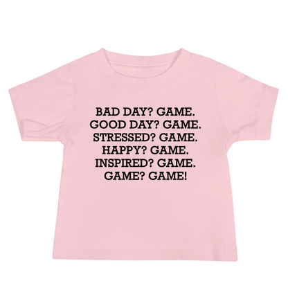 "Bad Day? Game. Good Day? Game. Stressed? Game. Happy? Game. Inspired? Game. Game? Game!" printed on a pink baby jersey short sleeve tee laying on a flat surface