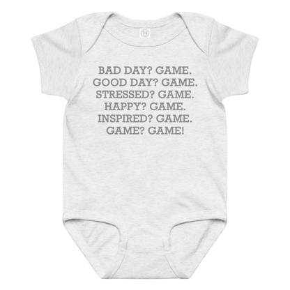 "Bad Day? Game. Good Day? Game. Stressed? Game. Happy? Game. Inspired? Game. Game? Game!" printed on a ash baby jersey bodysuit laying on a flat surface amongst other clothes