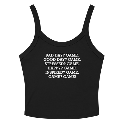 "Bad Day? Game. Good Day? Game. Stressed? Game. Happy? Game. Inspired? Game. Game? Game!" printed on a solid black blend women's micro-rib tanktop laying on a flat surface amongst sunglasses and shorts