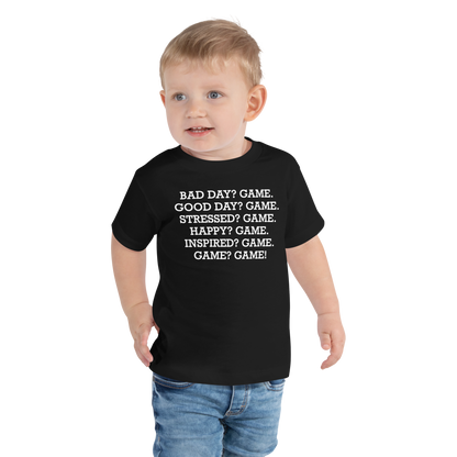 "Bad Day? Game. Good Day? Game. Stressed? Game. Happy? Game. Inspired? Game. Game? Game!" printed on a black toddler short sleeve tee worn by a male