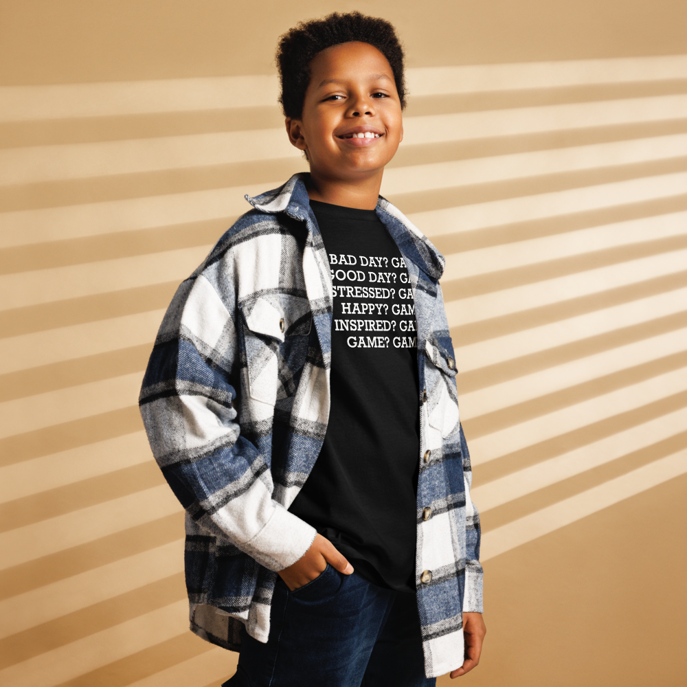 "Bad Day? Game. Good Day? Game. Stressed? Game. Happy? Game. Inspired? Game. Game? Game!" printed on a black youth classic tee worn by a male also wearing a jacket