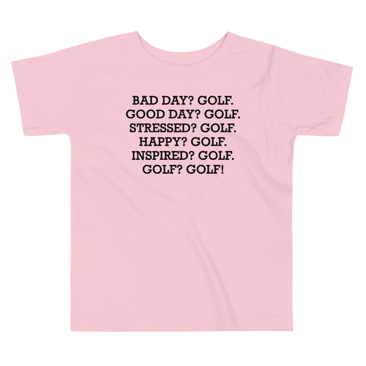 "Bad Day? Golf. Good Day? Golf. Stressed? Golf. Happy? Golf. Inspired? Golf. Golf? Golf!" printed on a pink toddler short sleeve tee laying on a flat surface