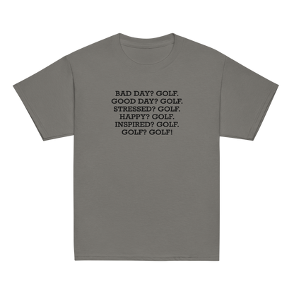 "Bad Day? Golf. Good Day? Golf. Stressed? Golf. Happy? Golf. Inspired? Golf. Golf? Golf!" printed on a charcoal youth classic tee laying on a flat surface