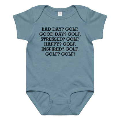 "Bad Day? Golf. Good Day? Golf. Stressed? Golf. Happy? Golf. Inspired? Golf. Golf? Golf!" printed on a vintage indigo baby jersey bodysuit laying on a flat surface amongst other clothes