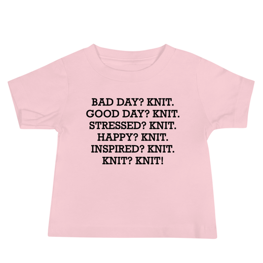 "Bad Day? Knit. Good Day? Knit. Stressed? Knit. Happy? Knit. Inspired? Knit. Knit? Knit!" printed on a pink baby jersey short sleeve tee laying on a flat surface