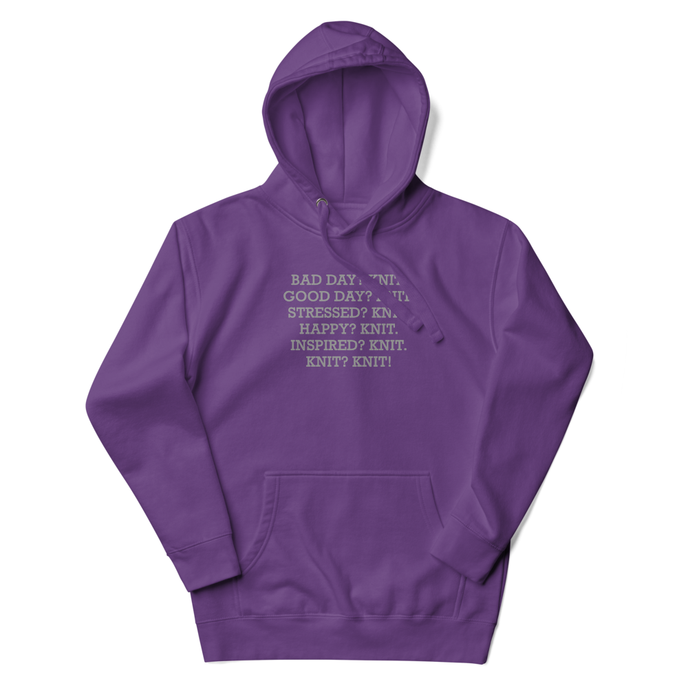 "Bad Day? Knit. Good Day? Knit. Stressed? Knit. Happy? Knit. Inspired? Knit. Knit? Knit!" printed on a purple unisex hoodie laying on a flat surface with the hood up