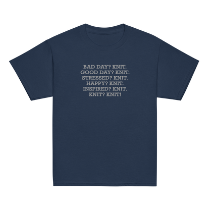 "Bad Day? Knit. Good Day? Knit. Stressed? Knit. Happy? Knit. Inspired? Knit. Knit? Knit!" printed on a navy youth classic tee laying on a flat surface