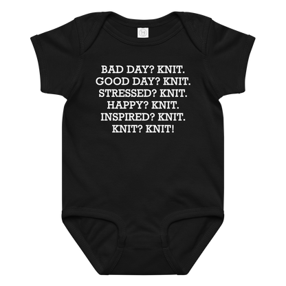 "Bad Day? Knit. Good Day? Knit. Stressed? Knit. Happy? Knit. Inspired? Knit. Knit? Knit!" printed on a black baby jersey bodysuit laying on a flat surface amongst other clothes