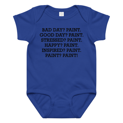 "Bad Day? Paint. Good Day? Paint. Stressed? Paint. Happy? Paint. Inspired? Paint. Paint? Paint!" printed on a royal baby jersey bodysuit laying on a flat surface amongst other clothes
