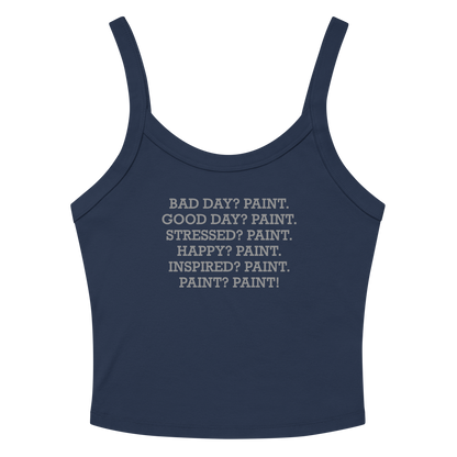 "Bad Day? Paint. Good Day? Paint. Stressed? Paint. Happy? Paint. Inspired? Paint. Paint? Paint!" printed on a solid navy blend women's micro-rib tanktop laying on a flat surface amongst sunglasses and shorts