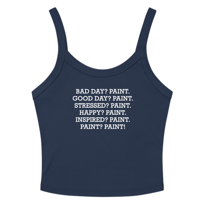 "Bad Day? Paint. Good Day? Paint. Stressed? Paint. Happy? Paint. Inspired? Paint. Paint? Paint!" printed on a solid navy blend women's micro-rib tanktop laying on a flat surface amongst sunglasses and shorts
