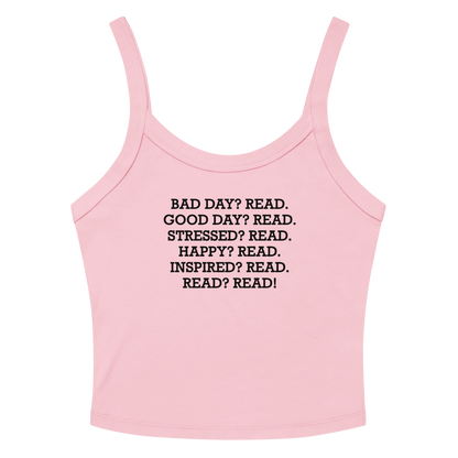 "Bad Day? Read. Good Day? Read. Stressed? Read. Happy? Read. Inspired? Read. Read? Read!" printed on a solid pink blend women's micro-rib tanktop laying on a flat surface amongst sunglasses and shorts