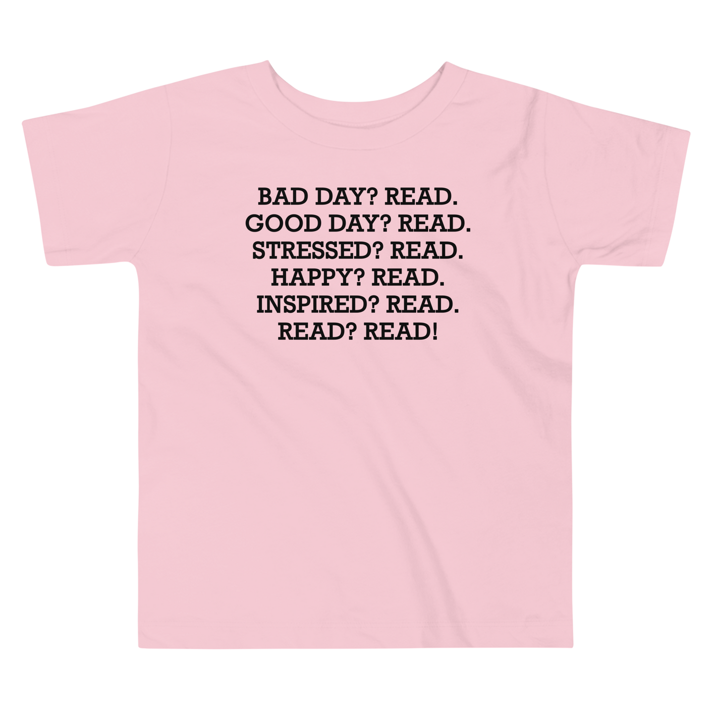"Bad Day? Read. Good Day? Read. Stressed? Read. Happy? Read. Inspired? Read. Read? Read!" printed on a pink toddler short sleeve tee laying on a flat surface