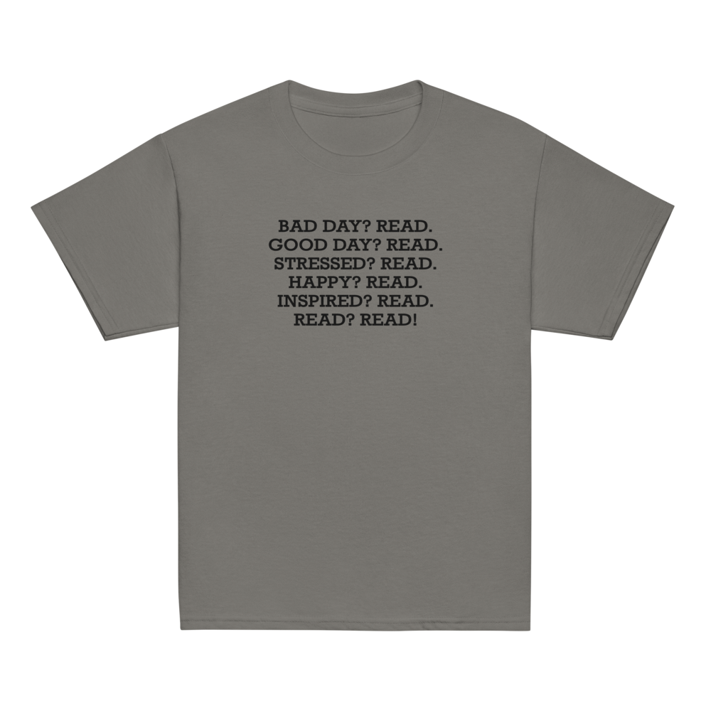 "Bad Day? Read. Good Day? Read. Stressed? Read. Happy? Read. Inspired? Read. Read? Read!" printed on a charcoal youth classic tee laying on a flat surface