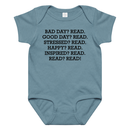 "Bad Day? Read. Good Day? Read. Stressed? Read. Happy? Read. Inspired? Read. Read? Read!" printed on a vintage indigo baby jersey bodysuit laying on a flat surface amongst other clothes