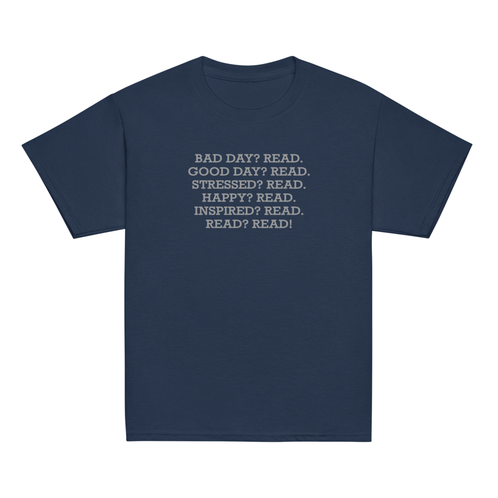 "Bad Day? Read. Good Day? Read. Stressed? Read. Happy? Read. Inspired? Read. Read? Read!" printed on a navy youth classic tee laying on a flat surface