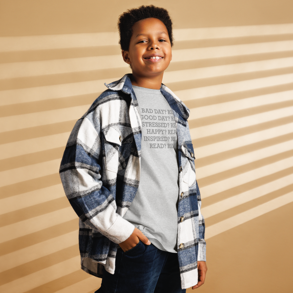 "Bad Day? Read. Good Day? Read. Stressed? Read. Happy? Read. Inspired? Read. Read? Read!" printed on a sport grey youth classic tee worn by a male also wearing a jacket