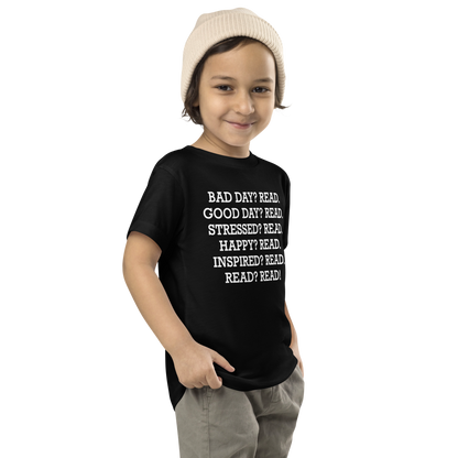"Bad Day? Read. Good Day? Read. Stressed? Read. Happy? Read. Inspired? Read. Read? Read!" printed on a black toddler short sleeve tee worn by a male who is also wearing a knit cap