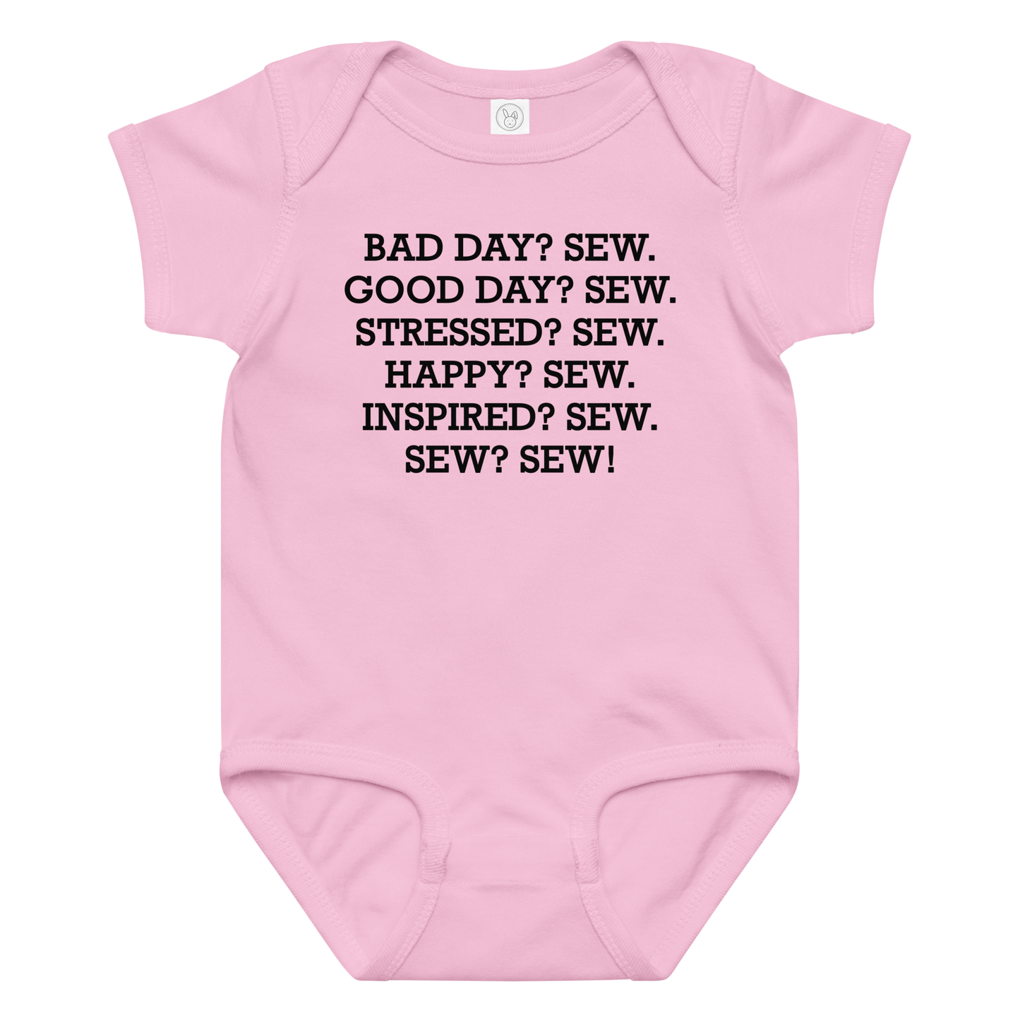 "Bad Day? Sew. Good Day? Sew. Stressed? Sew. Happy? Sew. Inspired? Sew. Sew? Sew!" printed on a pink baby jersey bodysuit laying on a flat surface amongst other clothes