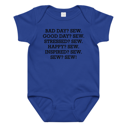 "Bad Day? Sew. Good Day? Sew. Stressed? Sew. Happy? Sew. Inspired? Sew. Sew? Sew!" printed on a royal baby jersey bodysuit laying on a flat surface amongst other clothes