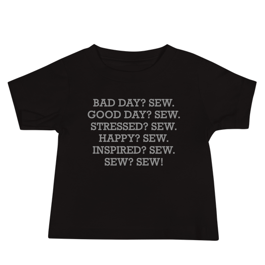 "Bad Day? Sew. Good Day? Sew. Stressed? Sew. Happy? Sew. Inspired? Sew. Sew? Sew!" printed on a black baby jersey short sleeve tee laying on a flat surface