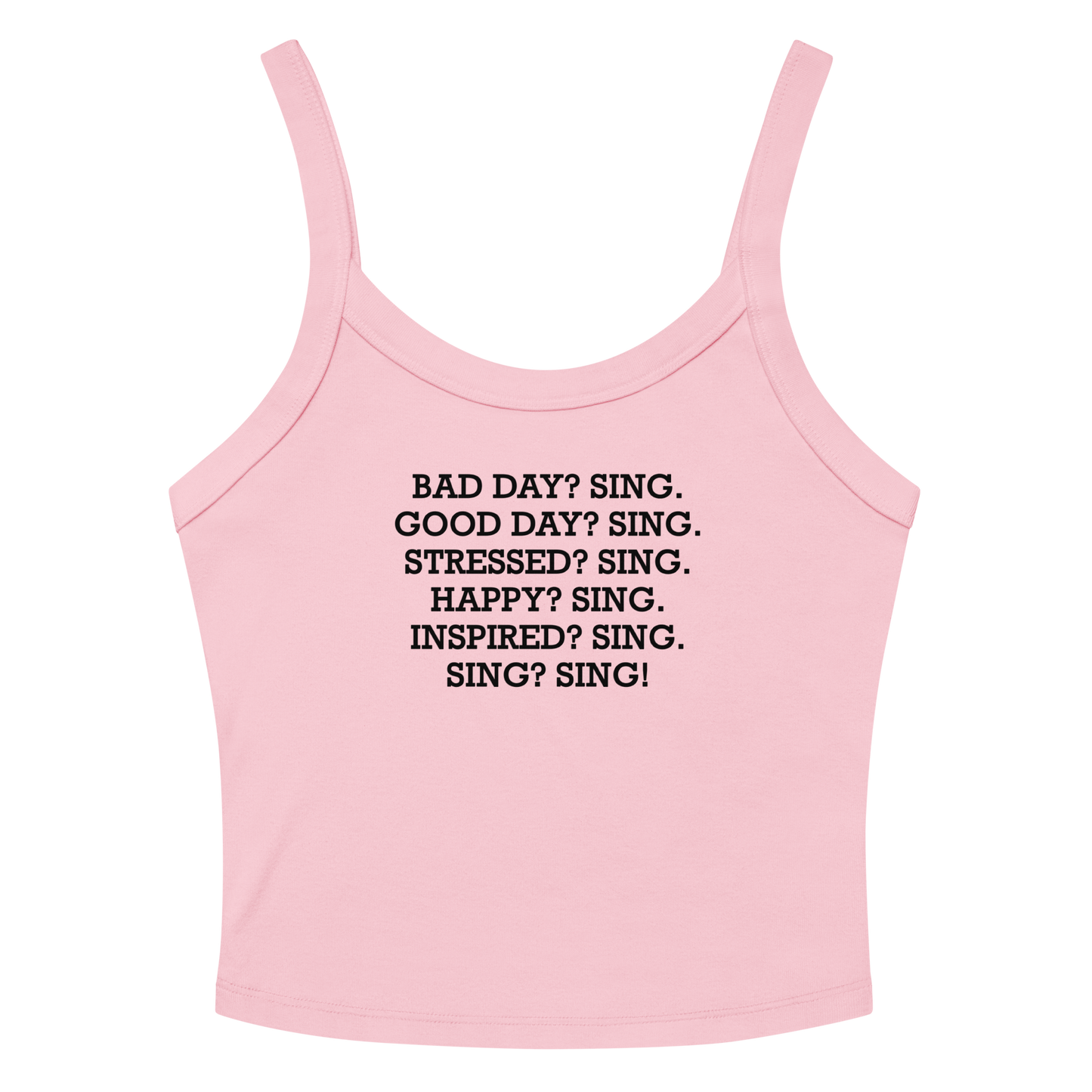 "Bad Day? Sing. Good Day? Sing. Stressed? Sing. Happy? Sing. Inspired? Sing. Sing? Sing!" printed on a solid pink blend women's micro-rib tanktop laying on a flat surface amongst sunglasses and shorts
