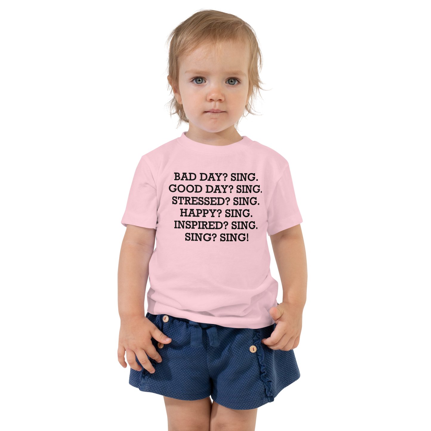 "Bad Day? Sing. Good Day? Sing. Stressed? Sing. Happy? Sing. Inspired? Sing. Sing? Sing!" printed on a pink toddler short sleeve tee worn by a female