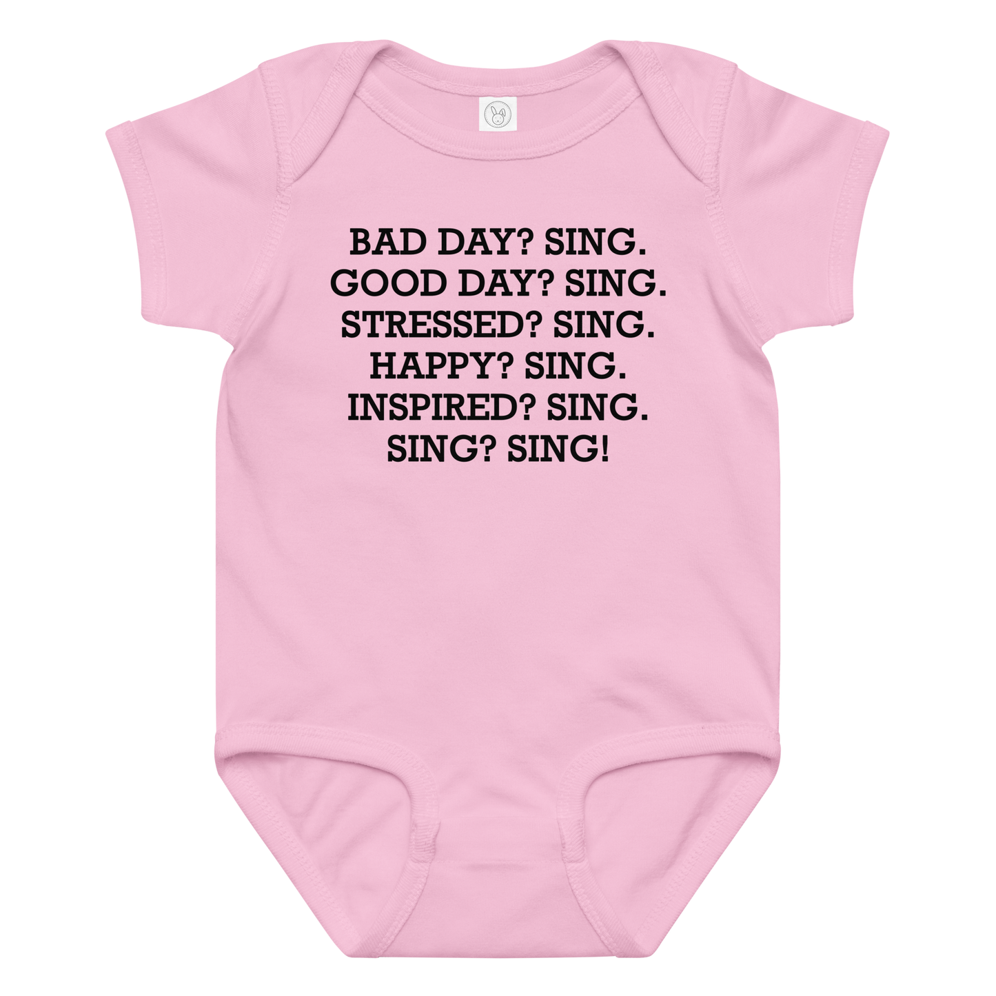 "Bad Day? Sing. Good Day? Sing. Stressed? Sing. Happy? Sing. Inspired? Sing. Sing? Sing!" printed on a pink baby jersey bodysuit laying on a flat surface amongst other clothes