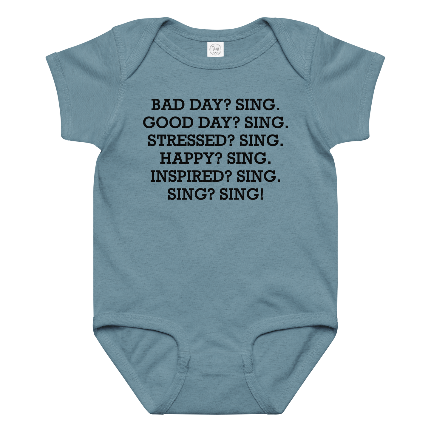 "Bad Day? Sing. Good Day? Sing. Stressed? Sing. Happy? Sing. Inspired? Sing. Sing? Sing!" printed on a vintage indigo baby jersey bodysuit laying on a flat surface amongst other clothes