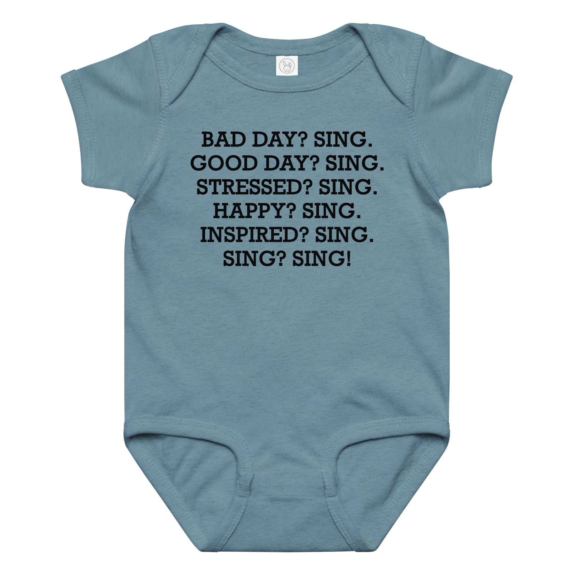 "Bad Day? Sing. Good Day? Sing. Stressed? Sing. Happy? Sing. Inspired? Sing. Sing? Sing!" printed on a vintage indigo baby jersey bodysuit laying on a flat surface amongst other clothes