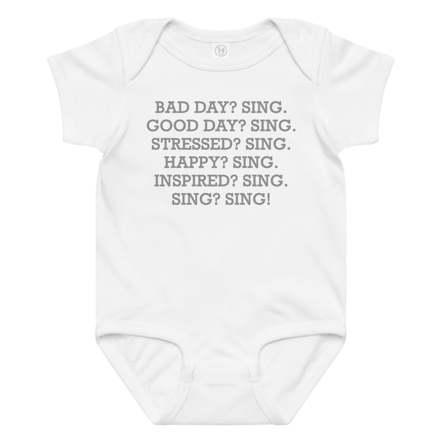 "Bad Day? Sing. Good Day? Sing. Stressed? Sing. Happy? Sing. Inspired? Sing. Sing? Sing!" printed on a white baby jersey bodysuit laying on a flat surface amongst other clothes